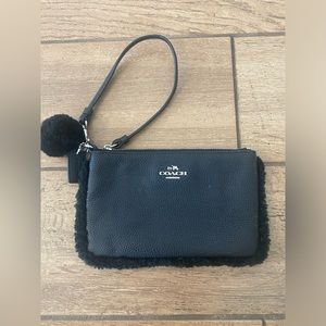 Coach wristlet with faux fur details. Used but in good condition